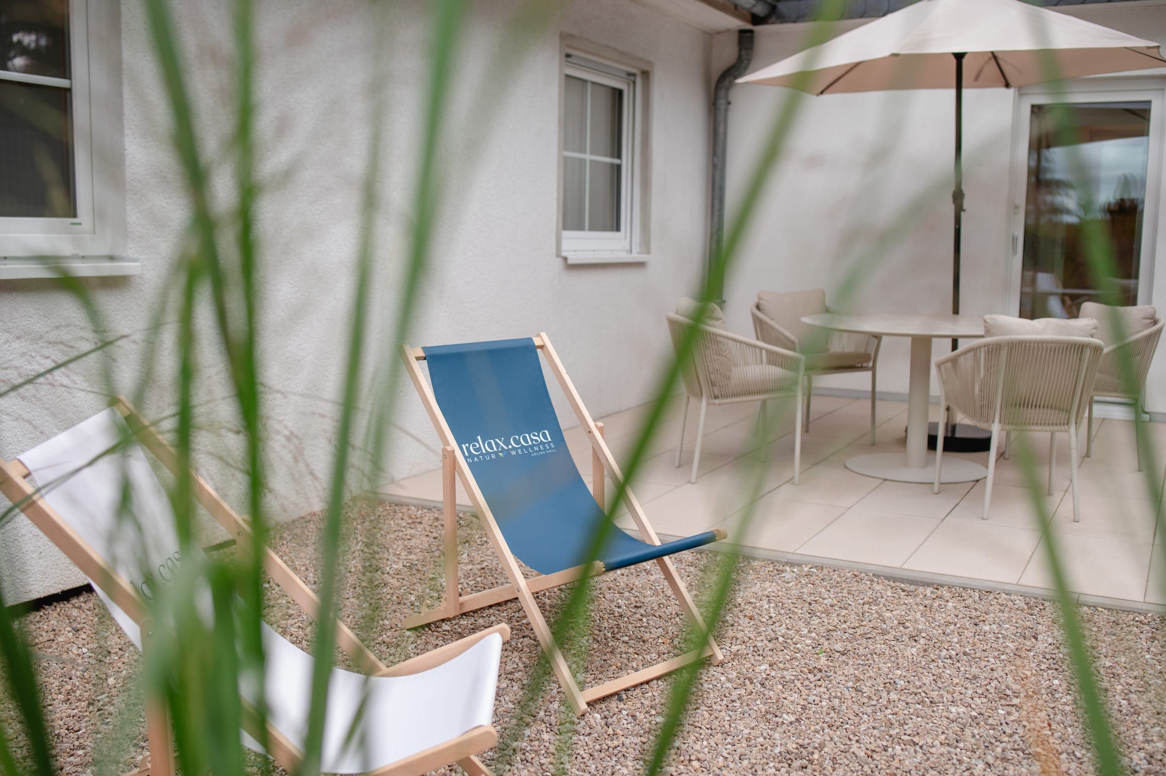 Liegestuhl auf der Terrasse, Ziergräser im Vordergrund
