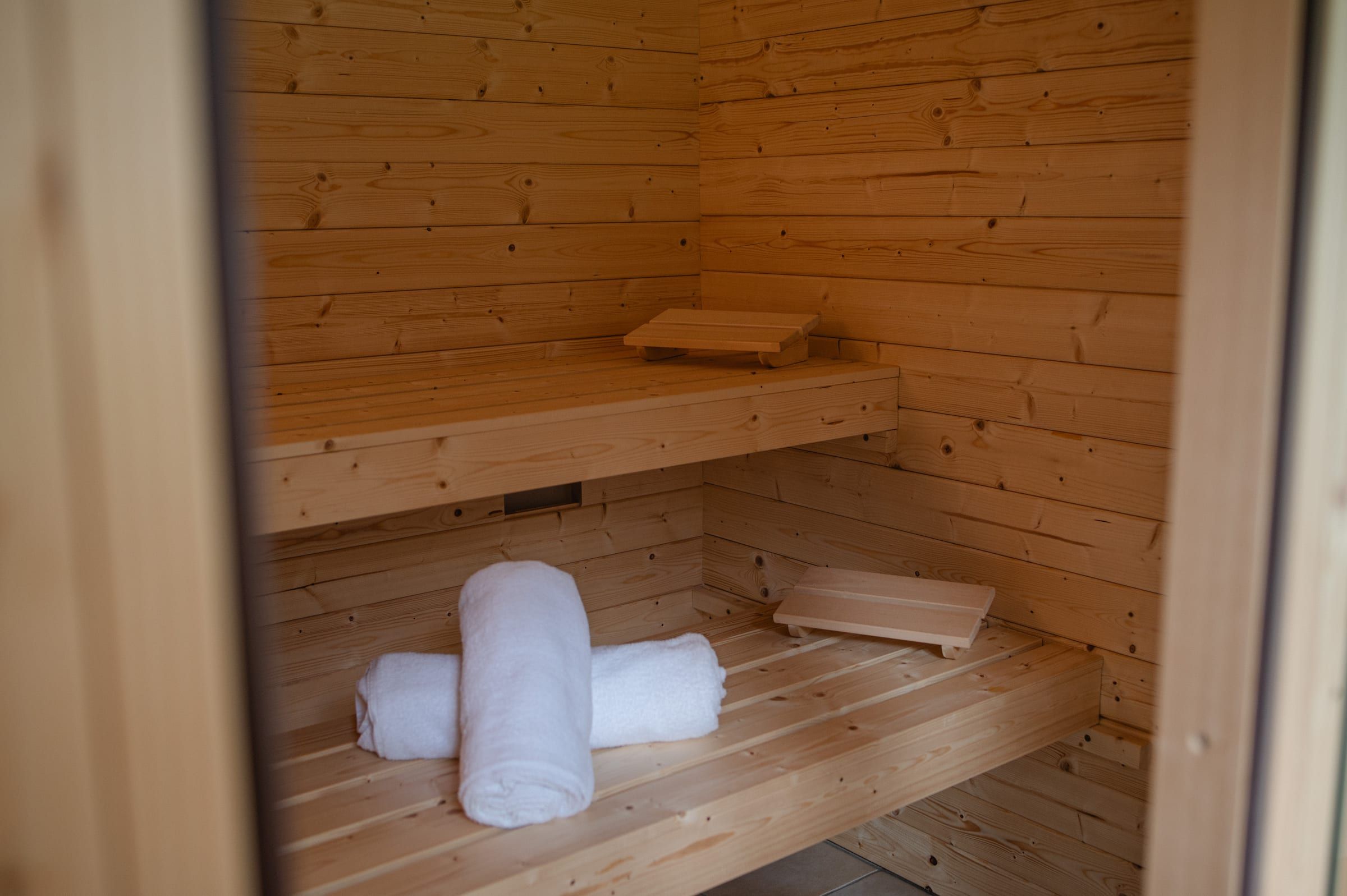 Finnische Sauna mit Holzbänken und bereitliegenden Handtüchern