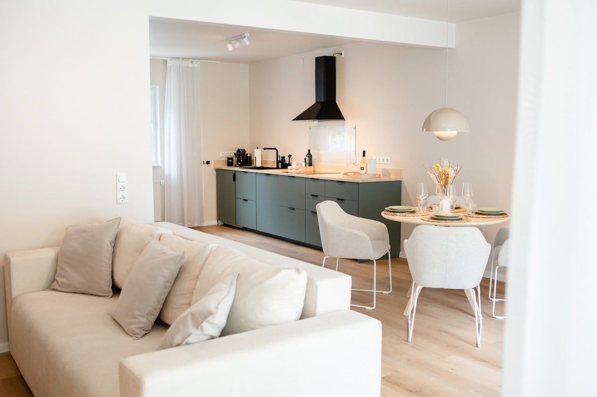Offener Wohnbereich mit Sofa und Küche im Hintergrund