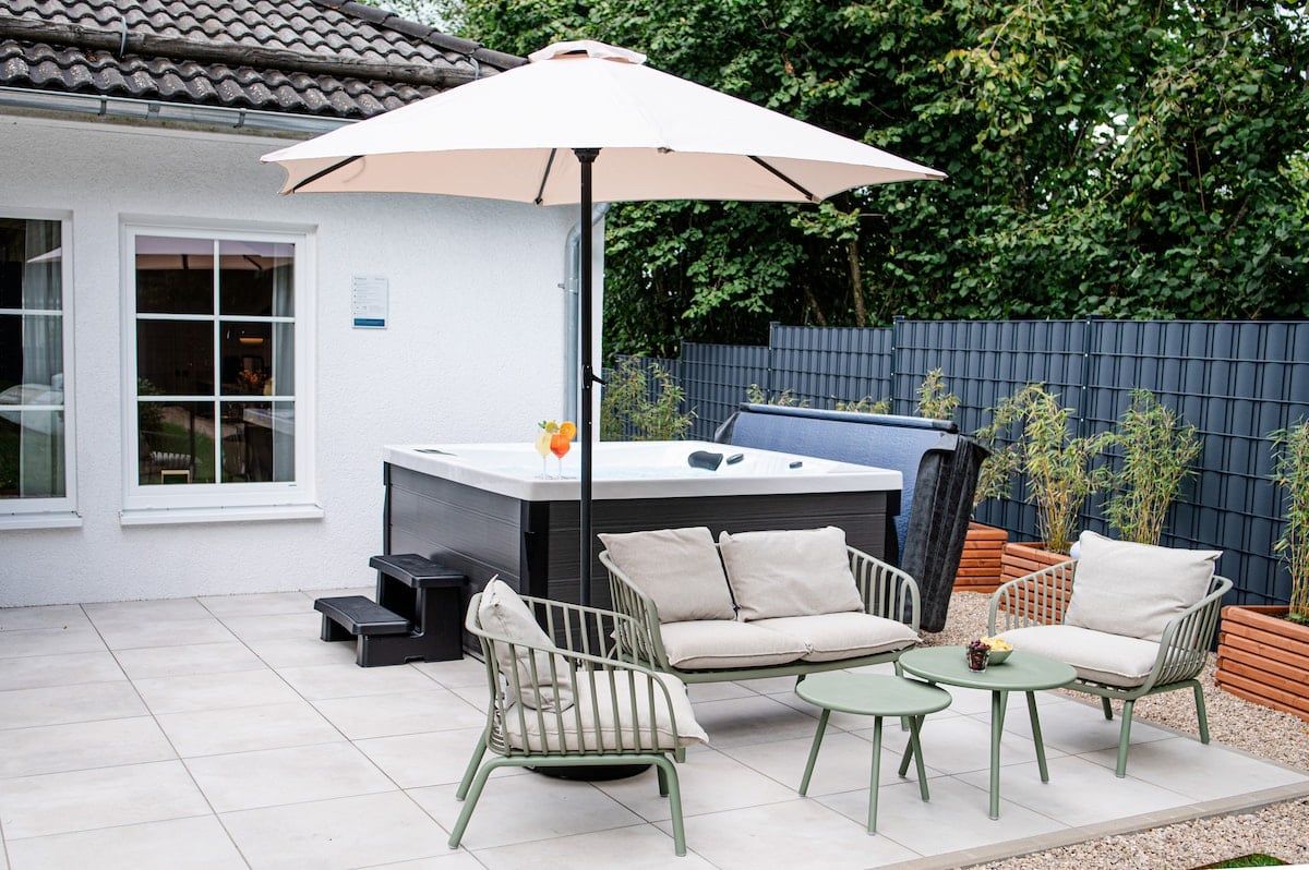 Terrasse mit Whirlpool und Sitzgruppe vor dem Haus