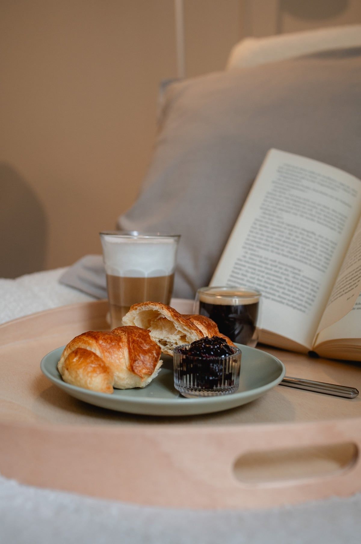 Croissants, Kaffee und ein aufgeschlagenes Buch auf dem Lesesessel